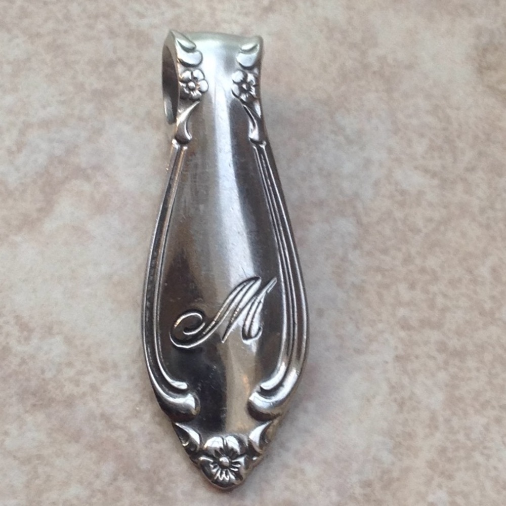 "M" monogrammed pendant.